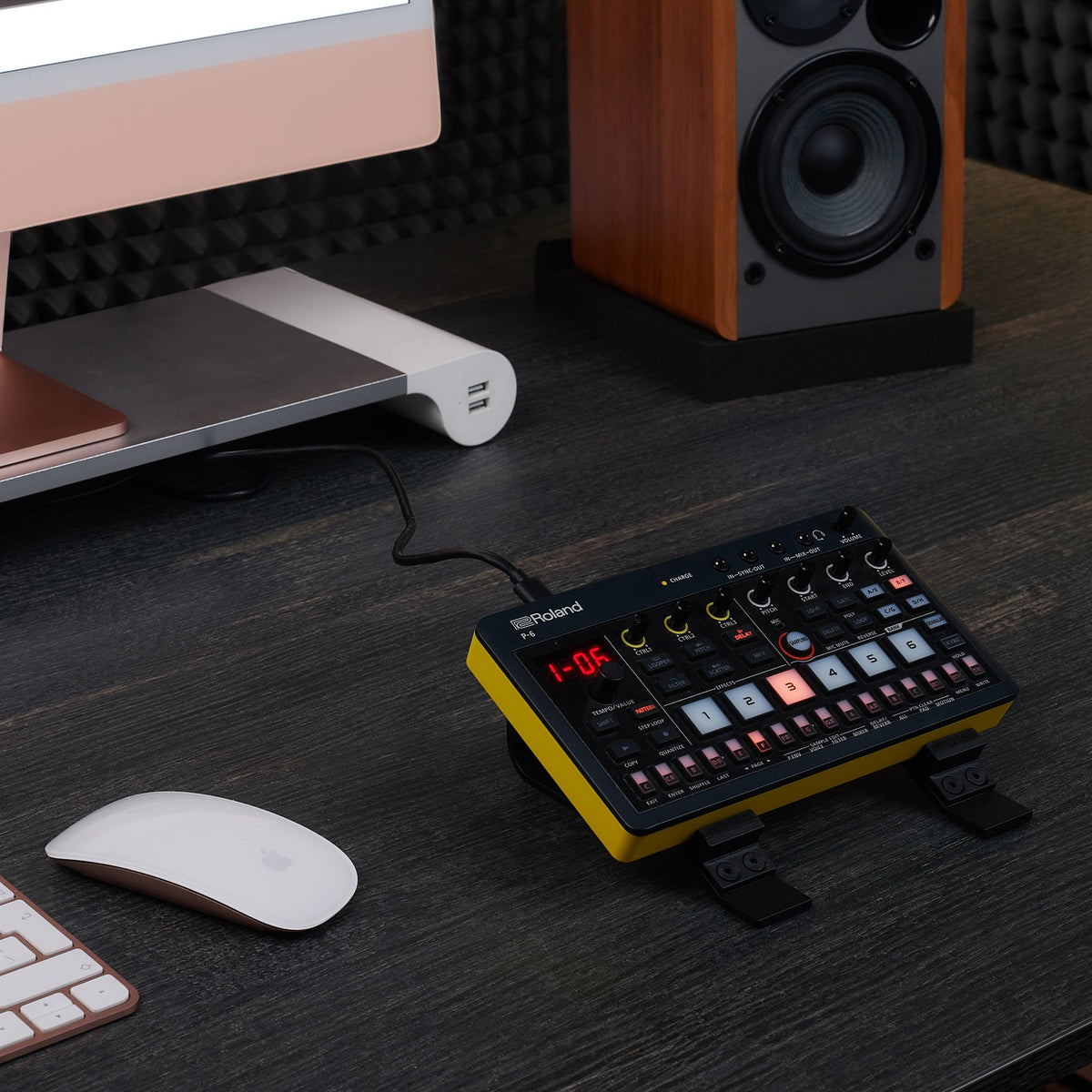 Roland AIRA Compact on the Sound Addicted stand in a home studio desk setup